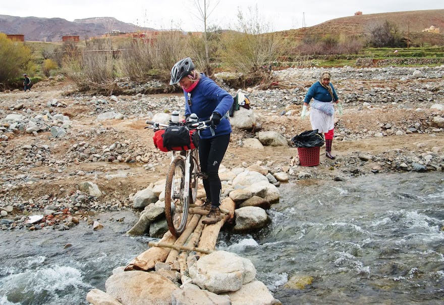 Crossing river with local woman hand washing laundry, Morocco
